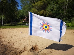 Waving Chaldean flag on sand beach
